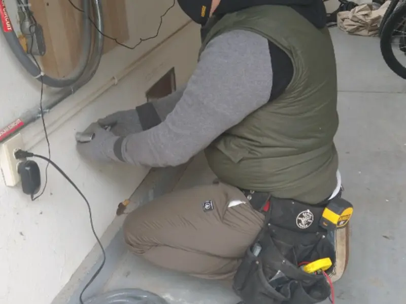 Electrician performing outlet wiring in a Peotone garage